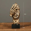 Sculpture Visage Doré Avec Main Expressive En Design Abstrait
